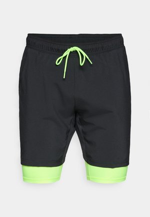 Bañadores negros con acentos en verde neón. Cuentan con una cintura elástica con cordón y un forro interior en contraste. Textura suave.