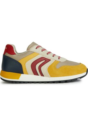 Sneaker sportivo in tessuto beige e suede giallo, con dettagli rossi e suola in gomma. Allacciato con lacci a strisce rosse e bianche.