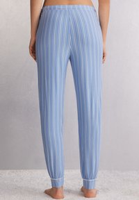Blauwe en witte gestreepte pyjamabroek met een taps toelopend ontwerp, voorzien van een elastische tailleband en manchet en gemaakt van lichtgewicht stof.