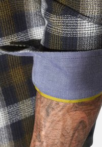 Hemden mit Kragen in einem karierten Muster in Marineblau, Gelb und Weiß. Verfügt über eine blaue Manschette mit einem gelben Akzent entlang des Randes. Strukturierter Stoff.