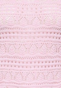 Tissu en tricot rose présentant des motifs en dentelle complexes avec des bandes de différents designs, incluant du travail ajouré et des bords festonnés.