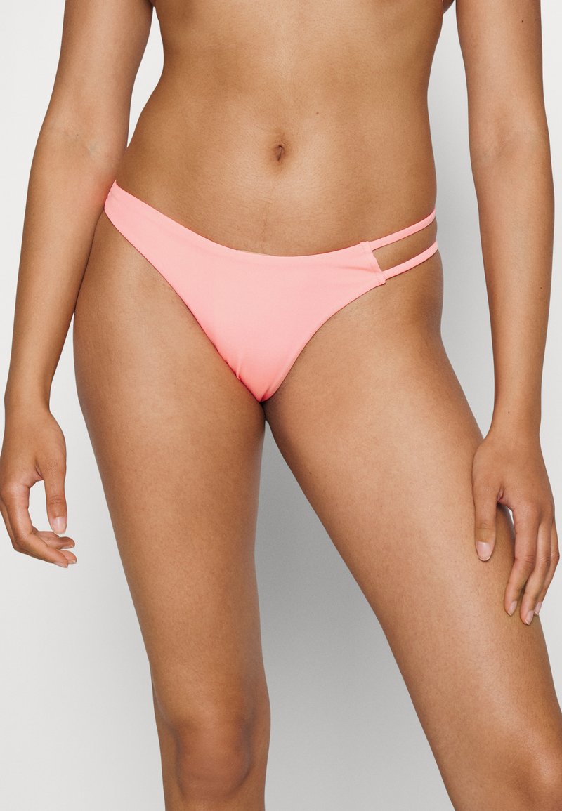 Tangas cor-de-rosa com textura suave, apresentando duas tiras laterais para um detalhe de design adicional. Corte clássico de baixa altura.