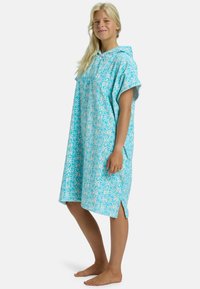 Poncho con capucha en tejido azul claro con patrones florales, mangas cortas, aberturas laterales y un ajuste holgado para mayor comodidad.