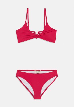Ensemble de bikini rouge comprenant un haut noué avec des bretelles réglables et un bas taille haute assorti, fabriqué en tissu extensible et lisse.