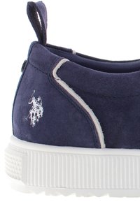 Námořnické semišové nazouvací boty s bílou gumovou podrážkou, kontrastním šitím a malým bílým logem hráče polo na boku.