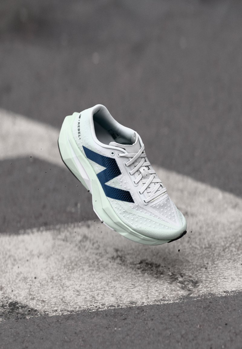 Lightweight running shoe featuring a breathable white mesh upper with navy accents, a textured patterned design, and a cushioned mint green sole.
