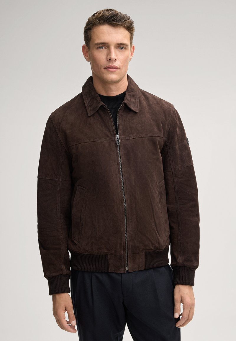 Bruine suede bomberjack met een rits aan de voorkant, puntige kraag, ribgebreide manchetten en een ribgebreide taille. Het jasje heeft zijzakken en een gladde textuur.