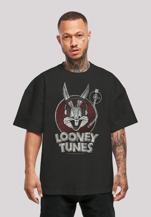 Sort oversized t-shirt med et grafisk billede af Bugs Bunny iført hovedtelefoner og teksten "Looney Tunes" i grå. T-shirt i bomuldsstof med en blød tekstur.