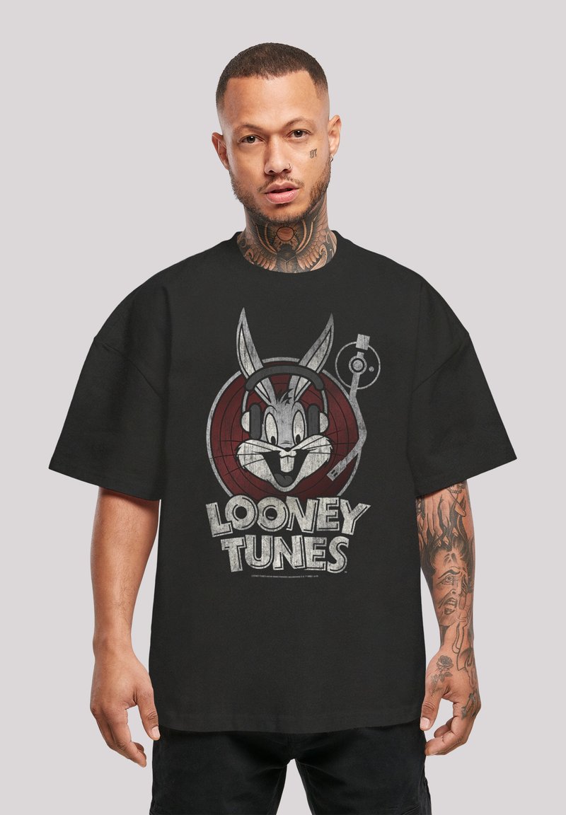 Črn oversize T-shirt z grafiko zajca Bunga z slušalkami ter besedilom "Looney Tunes" v sivi barvi. Iz bombažne tkanine z mehkimi vlakni.