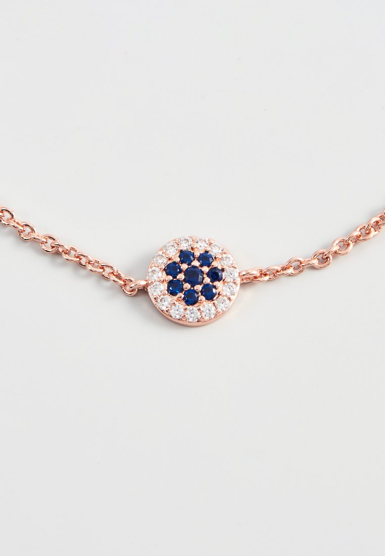 Bracelet en or rose avec un pendentif rond comportant un groupe de pierres précieuses bleu marine et transparentes, attaché à une chaîne délicate.