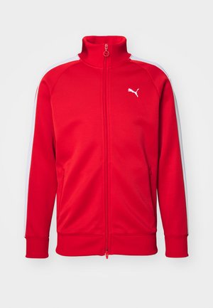 Rød zip-up træningsjakke med høj krave, hvide sidelister, ribbede manchetter og et lille hvidt logo på brystet. Glat stofstruktur.