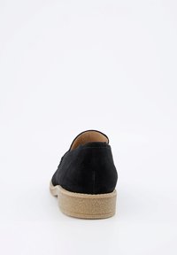 Scarpa in suede nera con retro arrotondato, suola in gomma color beige chiaro e cuciture sottili. Design minimalista senza hardware visibile o pattern.
