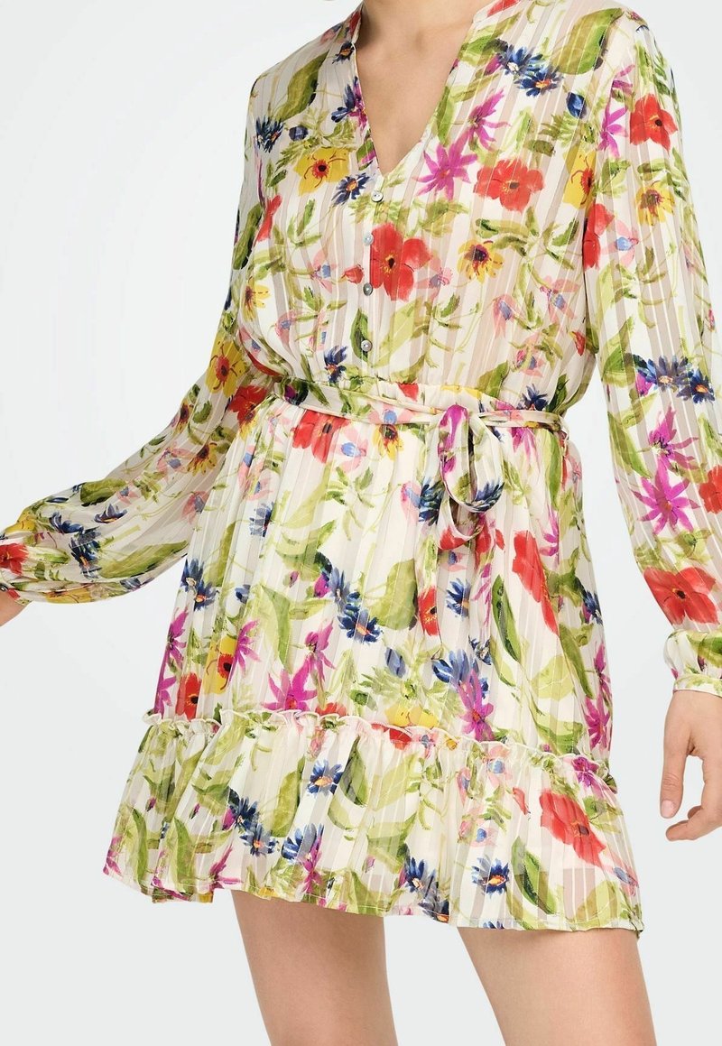 Robe fleurie à manches longues avec boutons, ceinture à la taille et ourlet volanté dans des tons verts, rouges, jaunes, bleus et roses sur fond clair.