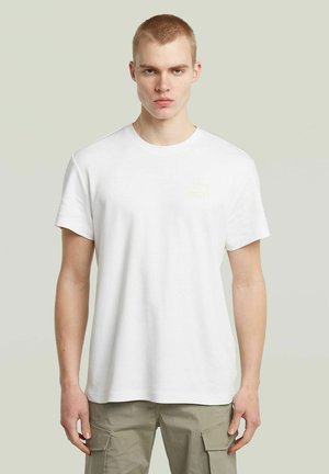 Weißes Baumwoll-T-Shirt mit kurzen Ärmeln, Rundhalsausschnitt und einem kleinen, hellgelben Logodetail auf der linken Brust; glatter, lässiger Schnitt.