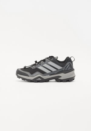 Black and grey hiking shoe with a textured surface, rubber sole, and three prominent grey stripes on the side; features a quick-lace system.