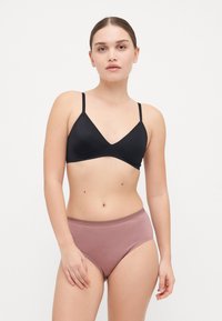 Black seamless bralette with a v-neck design, paired with high-waisted mauve cotton briefs. The fabric is smooth and stretchy.