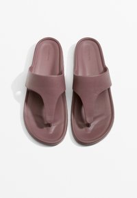 Sandale slide mauve cu o curea lată pentru degete și un design central de tip thong, fabricate dintr-un material sintetic neted cu o talpă texturată.
