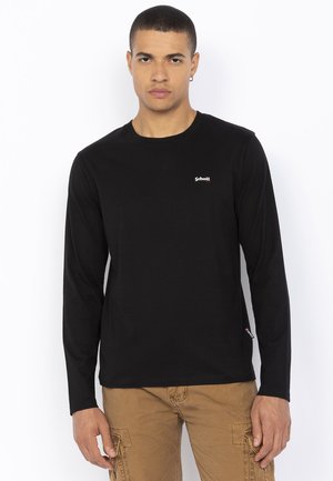 Zwarte lange mouwen t-shirt met een ronde hals en een klein wit logo op de borst; gemaakt van zachte stof met een gladde textuur.
