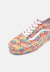 Barevné sneakers s kostkovaným vzorem v červené, žluté, zelené a modré barvě; bílé tkaničky a akcenty; pevný textilní svršek s tlustou podrážkou.