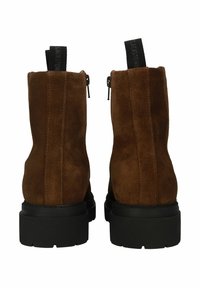 Botas de tobillo de ante marrón con un acabado texturizado, suela de goma negra y cierre de cremallera, con una pestaña en la parte posterior para facilitar su uso.