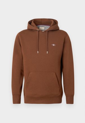 Sweat à capuche marron en matière douce ; comprend une poche avant, des cordons de serrage et un petit logo sur la poitrine. Texture lisse.
