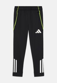 Zwarte sportieve broek van zachte stof, met contrasterende limoengroene zijstrepen en witte drie-strepen branding op de onderbenen.