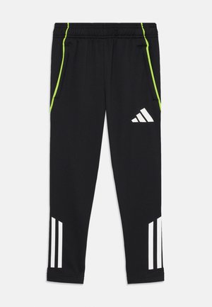 Pantalones deportivos negros de tela suave, con franjas laterales en lima y la marca de tres rayas en blanco en la parte inferior de las piernas.