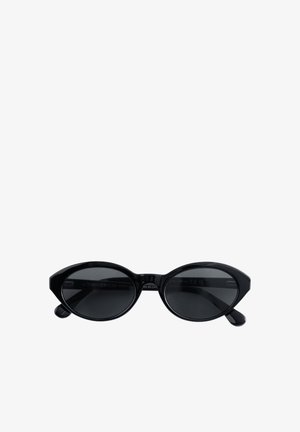 Zwarte cat-eye zonnebril met donker getinte glazen en glanzende monturen, van voren bekeken op een witte achtergrond.