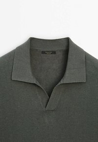 Polo en maille gris foncé avec col côtelé et ouverture en V courte, à plat sur fond blanc.