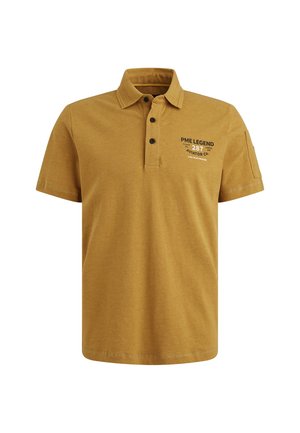 Polo shirt jaune moutarde en coton avec un plastron à trois boutons. Doté d'un texte imprimé en noir sur la poitrine et d'une poche sur la manche gauche.