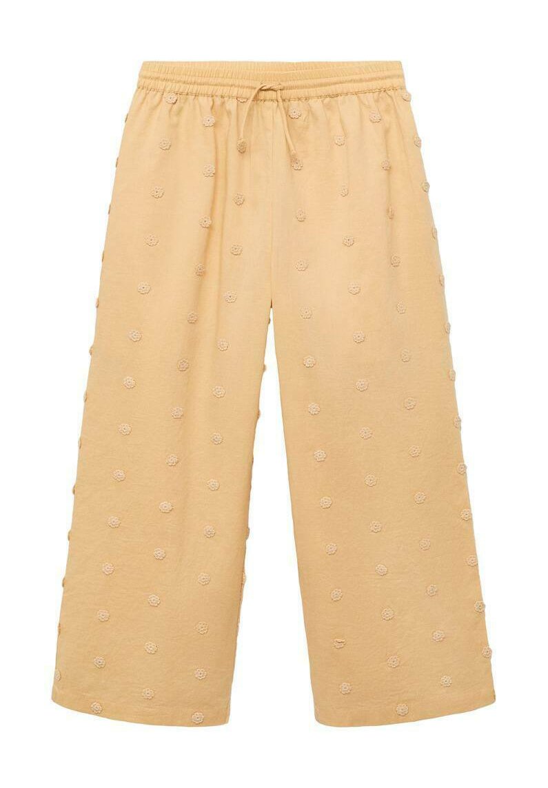 Pantalons en coton jaunes, cropped, avec une taille élastique, présentant une broderie florale texturée dans un motif répétitif sur l'ensemble du tissu.