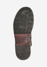 Semelle de chaussure en cuir avec caoutchouc noir texturé, arborant un logo en relief et des accents en cuir marron, affichant la taille 43.