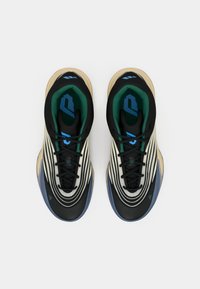 Paio di sneakers moderne con motivi neri, crema e blu, fodera interna verde e lacci neri, mostrati dall'alto su uno sfondo bianco.