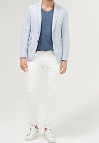 Světle modrý lněný blazer, námořnické tričko s kulatým výstřihem, bílé slim-fit džíny a bílé tenisky. Blazer m�á dvě přední kapsy a knoflíky.