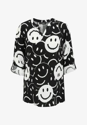 Schwarz-weißes Blusenshirt mit V-Ausschnitt, das mit einem Muster lächelnder Gesichter verziert ist. Hergestellt aus weichem Stoff mit Dreiviertelärmeln und hochgerollten Manschetten.