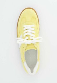 Žluté semišové tenisky s bílými akcenty, se zaoblenou špičkou, bílými tkaničkami a texturovanou gumovou podešví. Interiér má perforace.