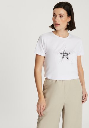 White cropped t-shirt featuring a black star design with leopard print in the center. Short sleeves and a round neckline.