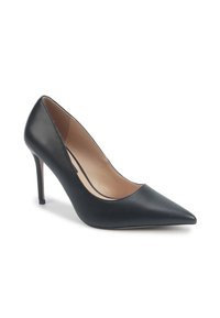 Pompe à talons aiguilles noires en cuir à bout pointu avec un talon stiletto mince et un intérieur beige sur fond blanc.