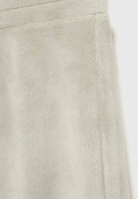 Soft, light green faux fur fabric with a smooth texture and stitched seams, showing a clean cut and no visible patterns or hardware.