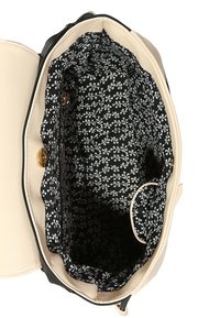 Bežová kožená kabelka s černou květinovou podšívkou, má hlavní přihrádku, patentní zapínání a vnitřní kapsy.