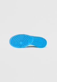 Nike-Sneakersohle mit einer blauen Gummisohle, die strukturierte Muster, Rillen und ein kreisförmiges Logo-Detail in der Mitte aufweist.