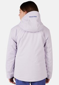 Giacca da sci viola chiaro con cappuccio, con un logo visibile sul retro, texture liscia e vestibilità strutturata.