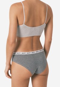 Grijze bralette met dunne bandjes en bijpassende grijze hipsterbroekjes met een witte tailleband waarop "SNOOPY" gedrukt staat. Glad textuur.