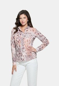 Blusa a maniche lunghe, con bottoni, in una stampa animale di rosa chiaro e beige. Realizzata in un tessuto morbido, presenta un colletto e una discreta lavorazione dei bottoni.