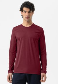 Langärmliges, kastanienbraunes Hemd aus leichtem Stoff mit Rundhalsausschnitt, glatter Textur und minimalen Nähten.