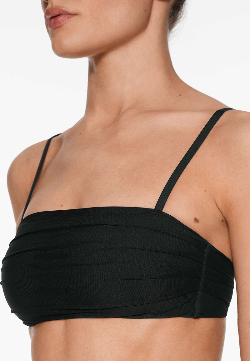 Top bandeau negro con tirantes finos, con textura plisada y un acabado suave, diseñado para la comodidad y el estilo.