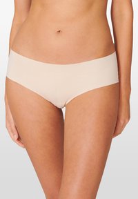 Beige hipster onderbroeken gemaakt van een gladde stof met een naadloos ontwerp, voorzien van een brede, elastische tailleband en een comfortabele pasvorm.