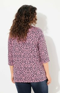 Roze top met een marineblauw abstract patroon, driekwart mouwen en een losse pasvorm. De stof heeft een gladde textuur.