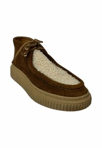 Botín de ante marrón con un forro de lana texturizada en color crema, punta redondeada, suela plana de goma y cierre de cordones a juego.