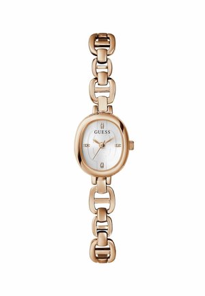 La montre-bracelet de couleur dorée présente un cadran ovale avec un fond blanc, le logo "GUESS" et des accents en pierres sur les marqueurs horaires. Design de bracelet à maillons.